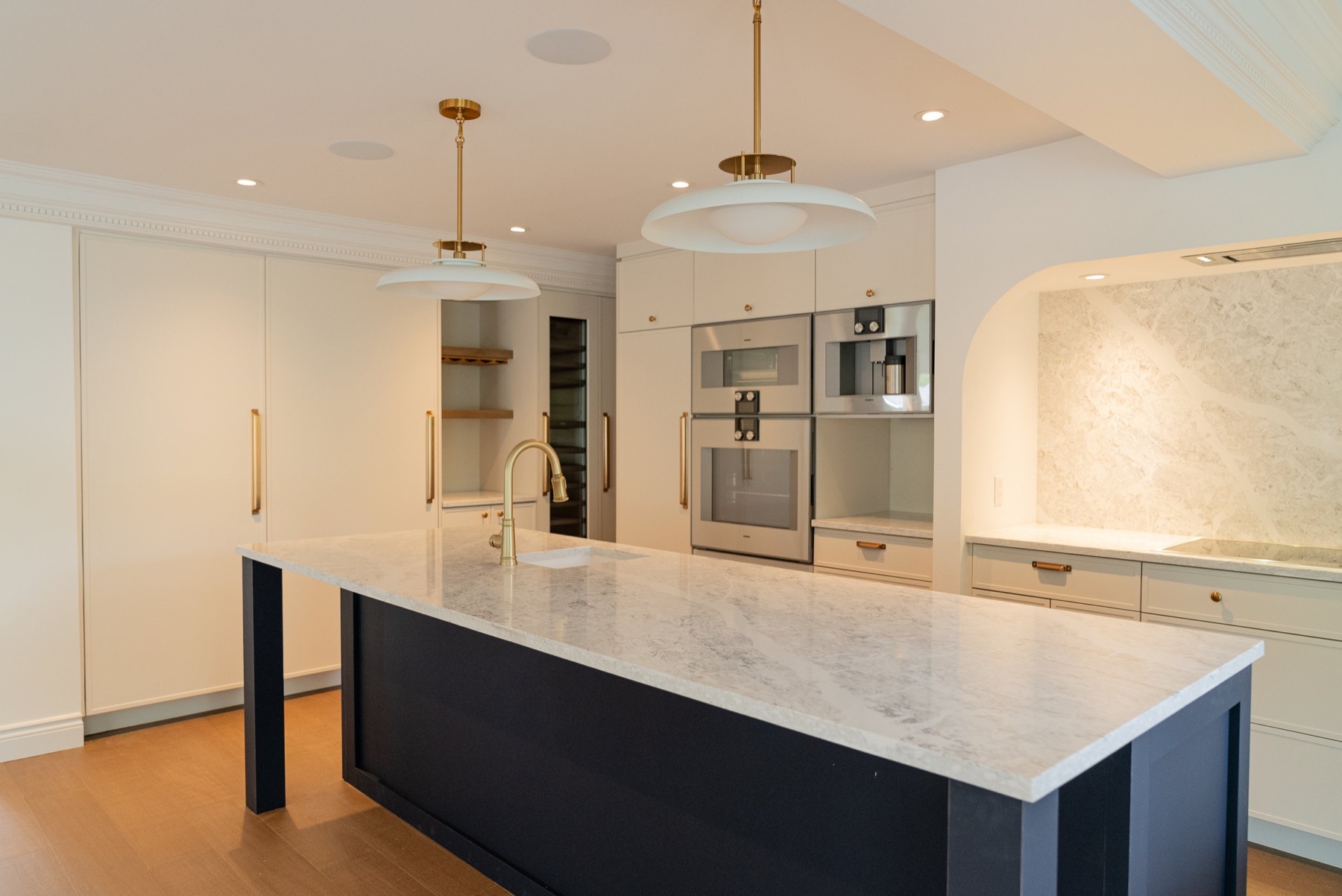 Renovated kitchen with marble island, brass fixtures and custom cabinetry by Maison SK